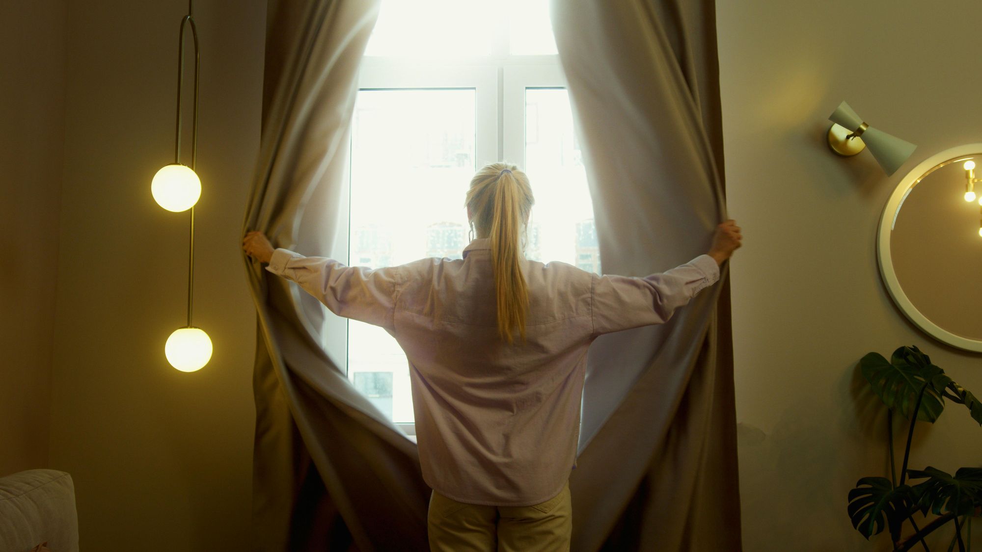 -Une-femme-ouvrant-les-rideaux-de-sa-chambre