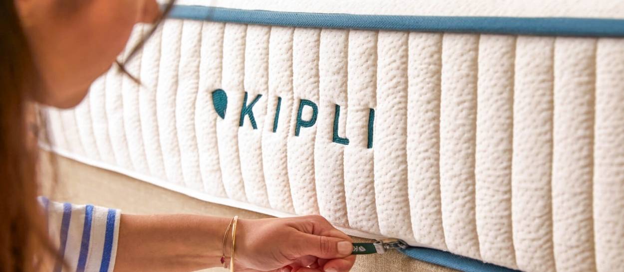 Main fermant la housse d’un matelas Kipli en latex naturel avec fermeture zippée pratique