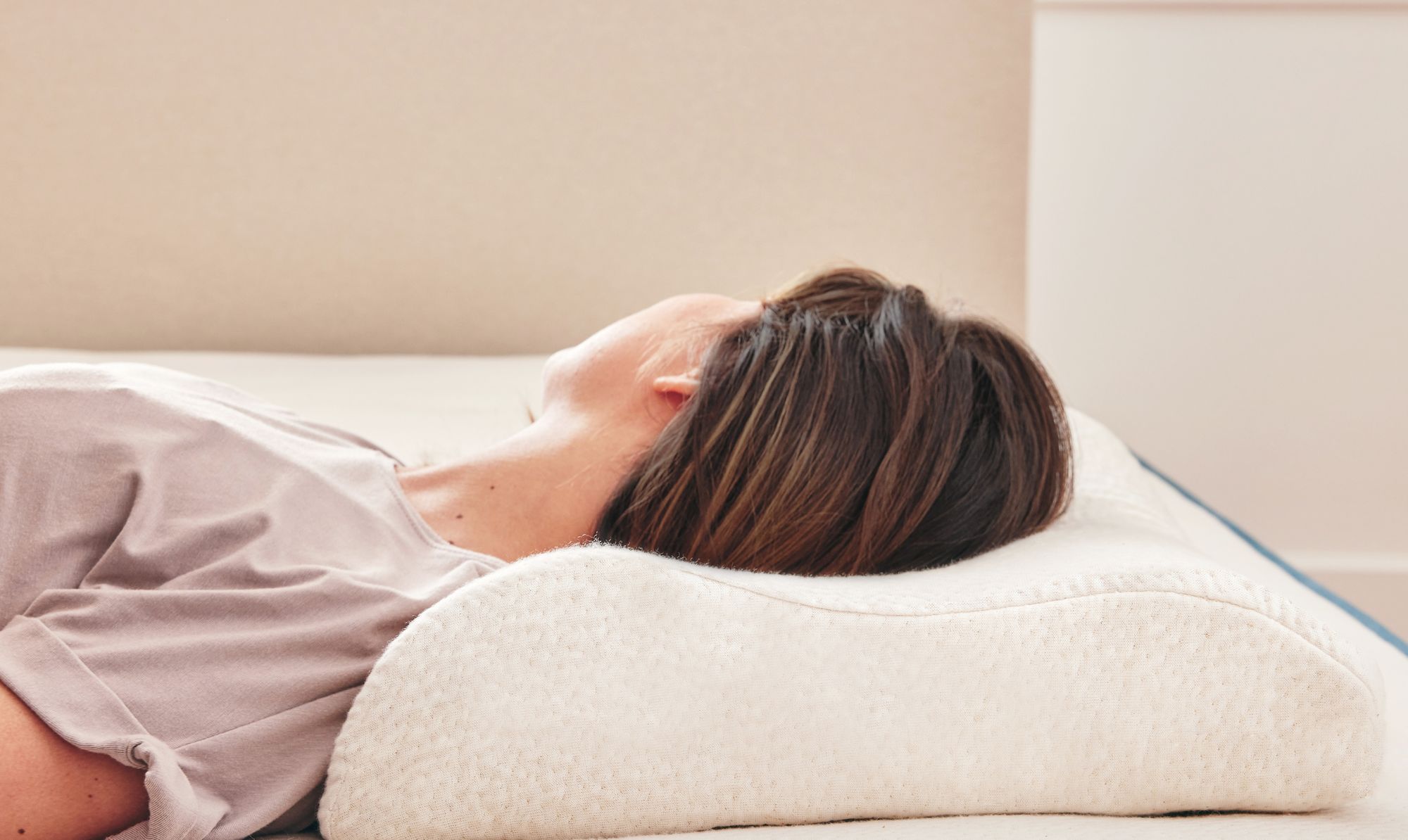 Femme allongée de profil sur un oreiller ergonomique en latex naturel, nuque bien alignée pour un soutien respirant et durable.