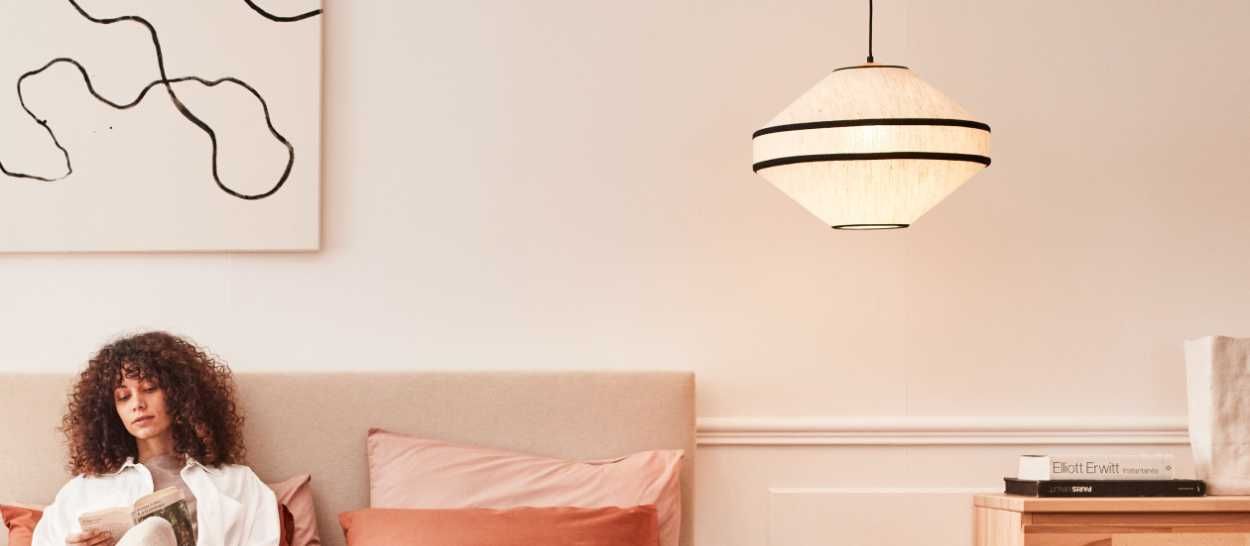 Femme dormant paisiblement sur un matelas Kipli en latex naturel sous une lumière Kipli apaisante favorisant le sommeil profond