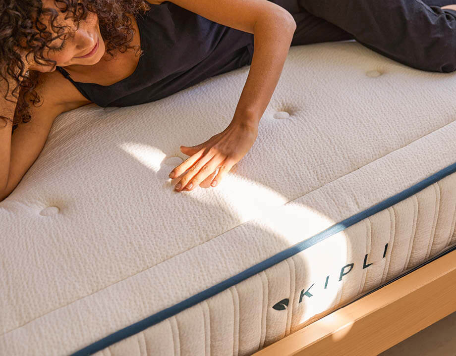 Femme allongée sur un matelas Kipli en latex naturel offrant un soutien optimal du dos