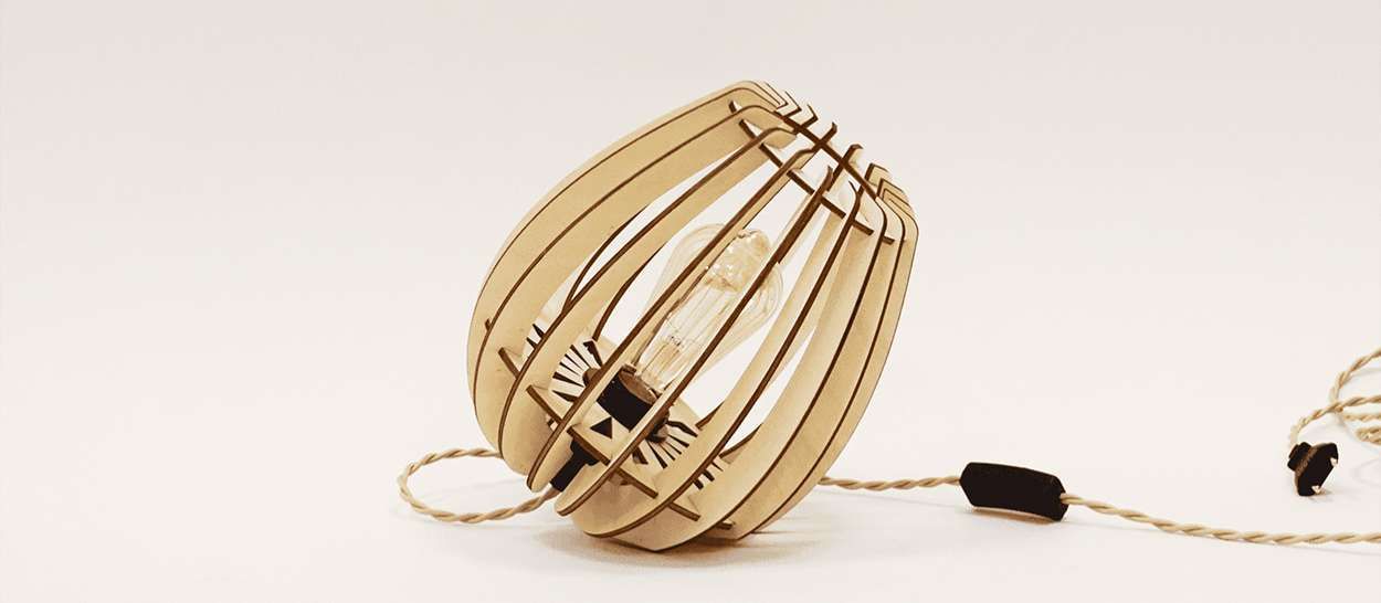 Lampe à poser en bois ATOME en forme de sphère avec ampoule apparente et cordon torsadé sur fond clair