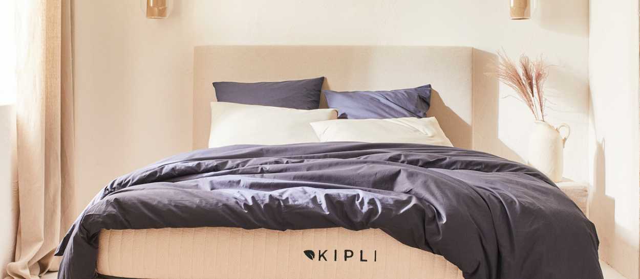 Lit Kipli avec sommier tapissier et matelas dans une chambre lumineuse