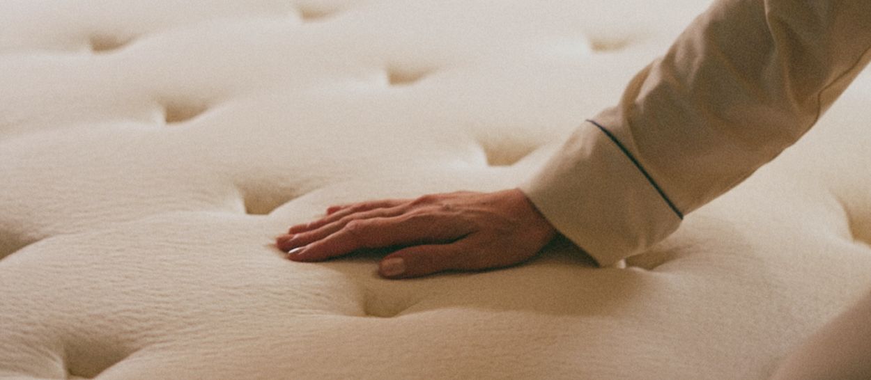 main posée sur la surface moelleuse d’un matelas en latex naturel Kipli pour illustrer le confort et la tenue dans le temps