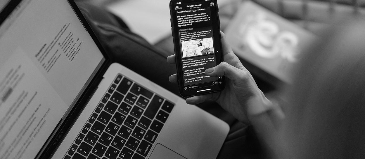 Personne utilisant un smartphone et un ordinateur portable en soirée, illustrant l’exposition aux écrans et à une lumière proche des yeux pouvant perturber l’endormissement.