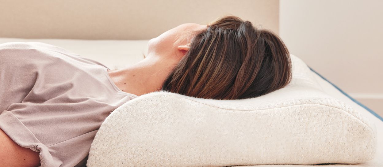 Oreiller ergonomique en latex naturel Kipli soutenant la nuque d’une personne allongée, montrant la forme guidée et l’épaisseur différenciée