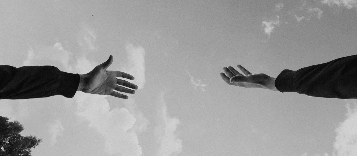 Deux mains qui se tendent l’une vers l’autre, illustrant le soutien, l’accompagnement et le dialogue autour des usages des écrans et du sommeil chez les adolescents.