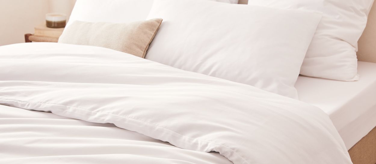 linge de lit blanc en matières naturelles illustrant une literie respirante favorisant la régulation thermique pendant le sommeil