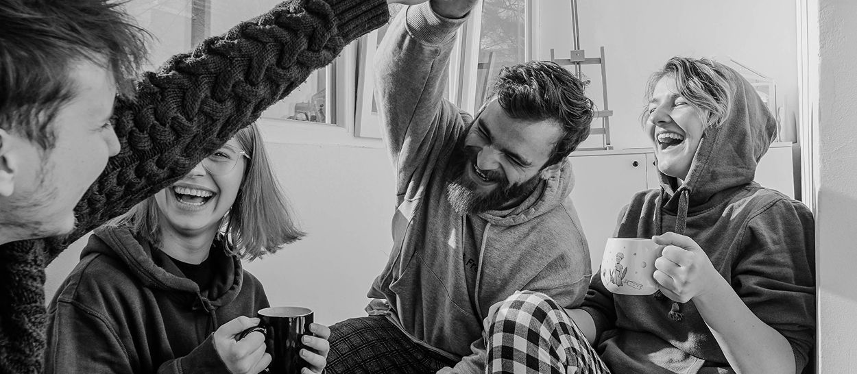 Groupe de personnes riant ensemble avec des tasses de café, bien-être et bonne humeur, qualité de vie