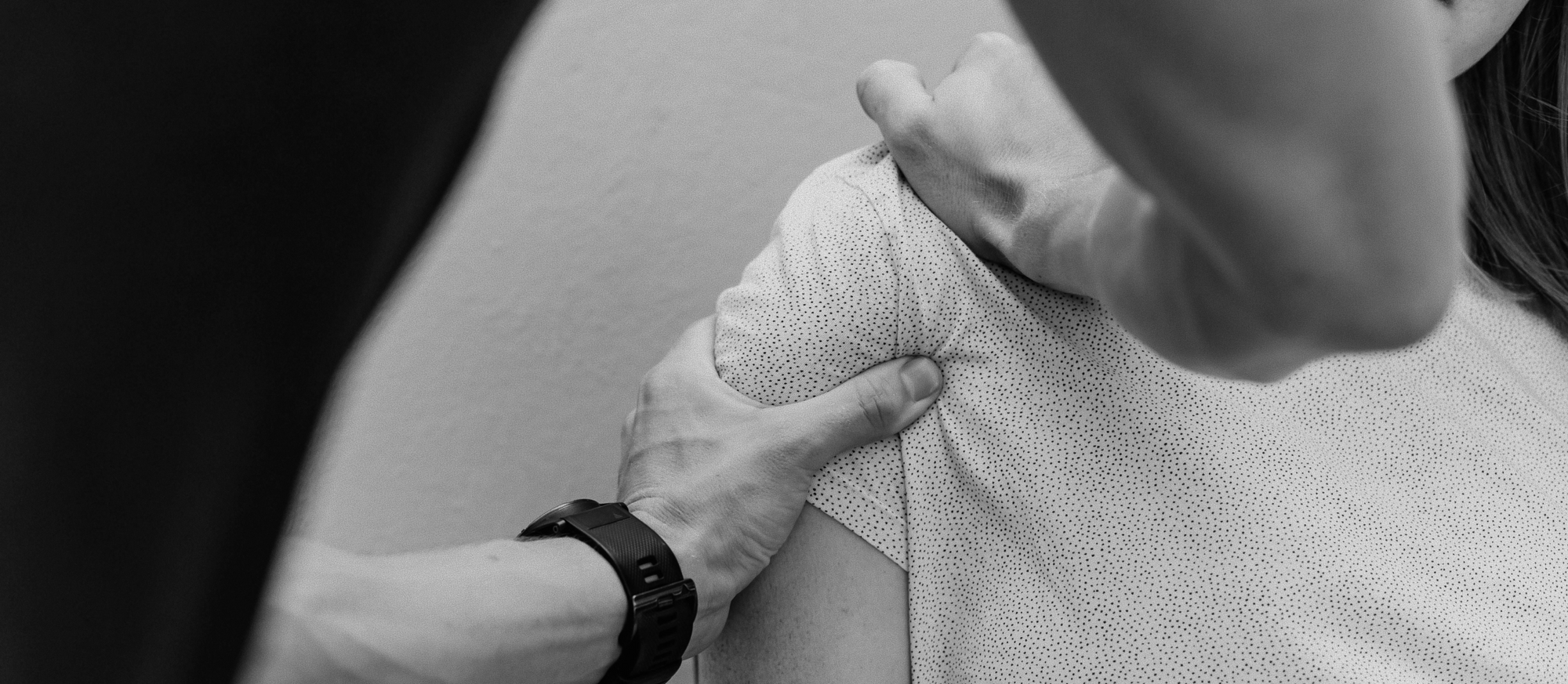 Main de praticien posée sur l'épaule d'un patient, geste de consultation médicale