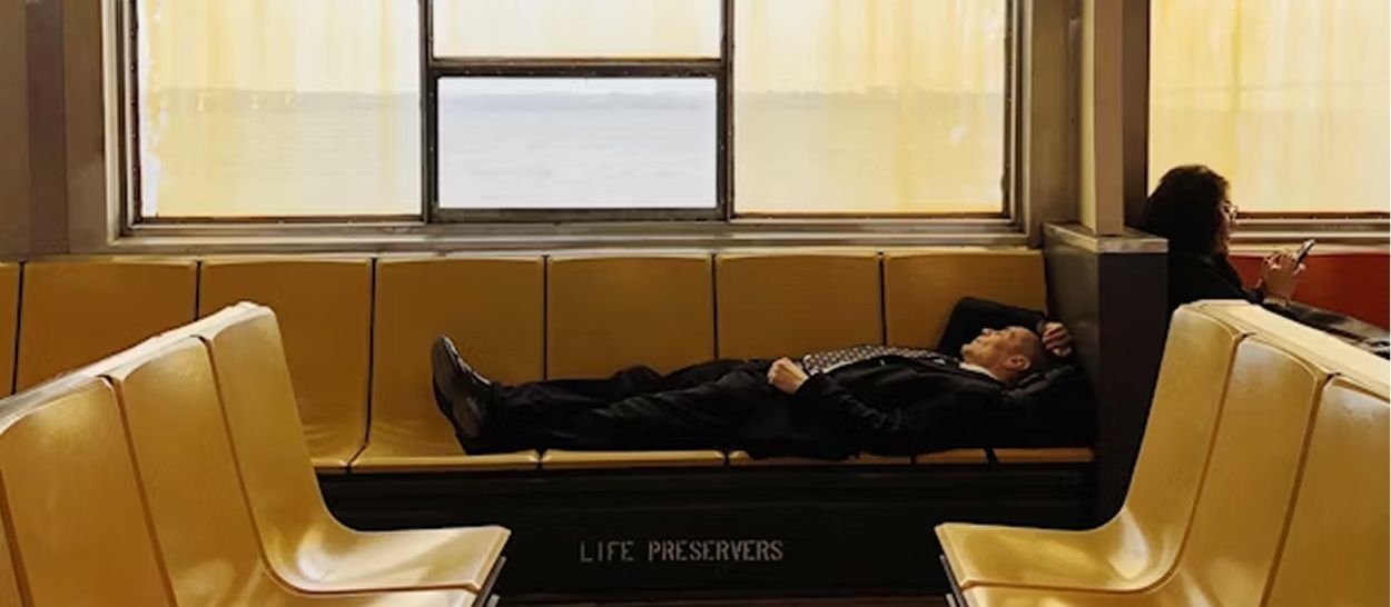 Homme endormi sur banc de transport, conséquence de la dette chronique de sommeil