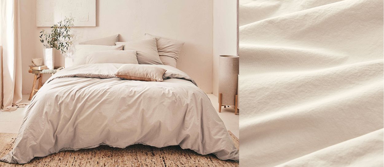 Chambre avec lit en coton lavé taupe froissé, aspect naturel doux et léger, gros plan texture