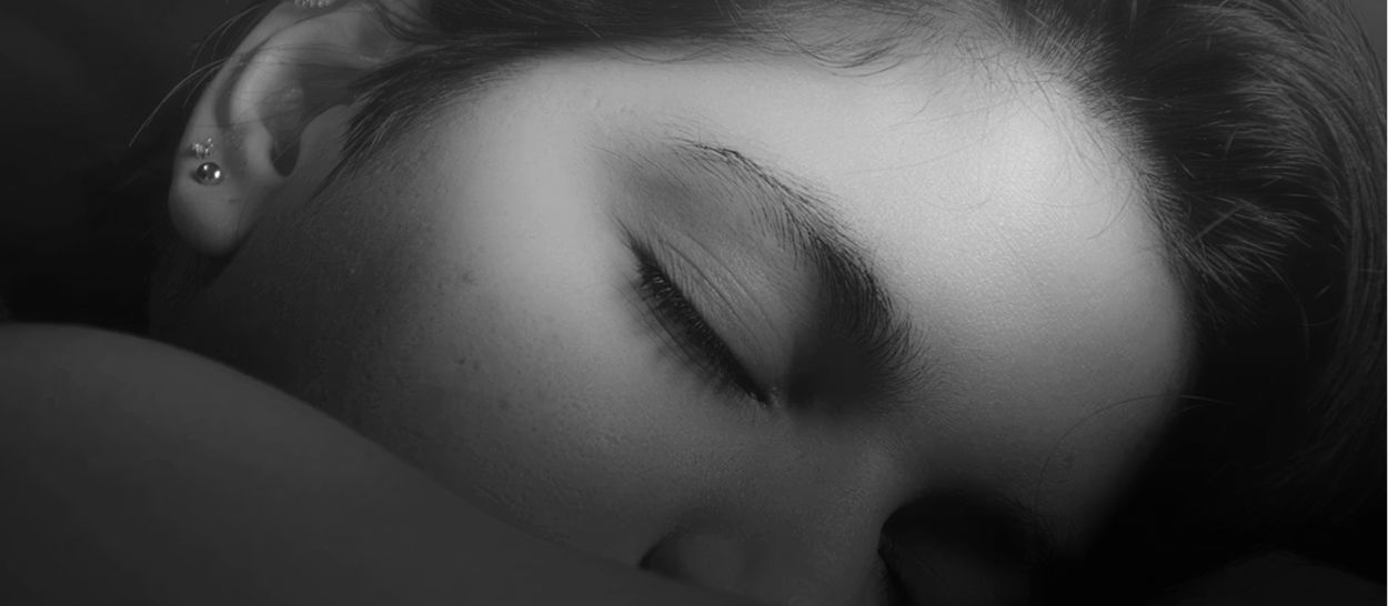 Femme dormant paisiblement, illustrant sommeil réparateur et récupération de la dette