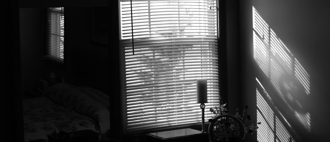 Chambre avec volets occultants fermés et ventilateur montrant astuce pour garder fraîcheur pendant canicule