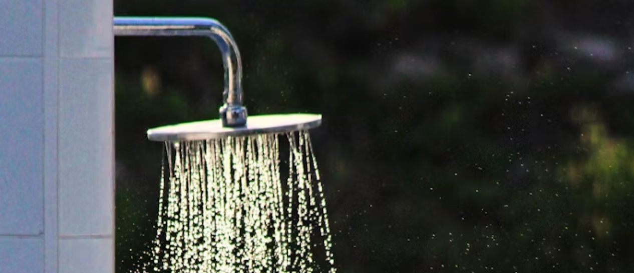 Pomme de douche eau tiède montrant astuce refroidissement corporel avant coucher pendant canicule