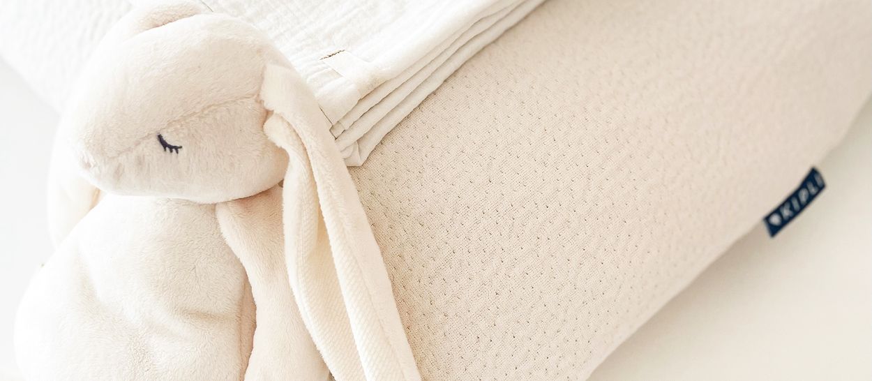 Oreiller enfant Kipli crème avec peluche et livres montrant soutien adapté et sécurité pour enfants