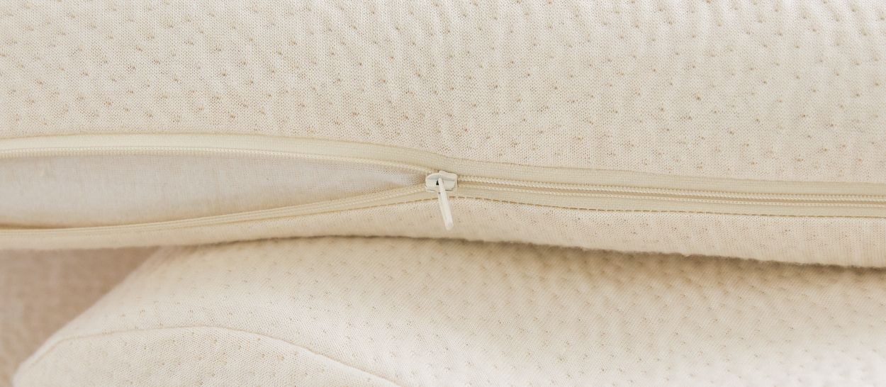 Gros plan housse oreiller ergonomique amovible montrant courbures différenciées et qualité de finition