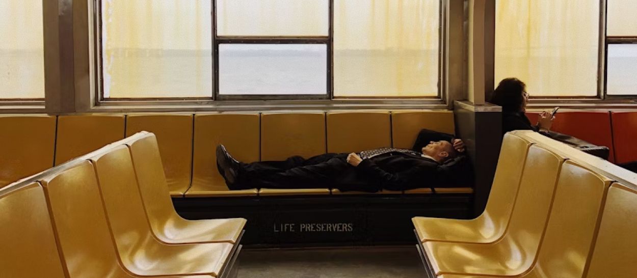 Personne dormant sur un banc public dans un endroit inattendu, illustrant la fatigue et le sommeil fragmenté causés par un dérèglement du cortisol et du stress chronique