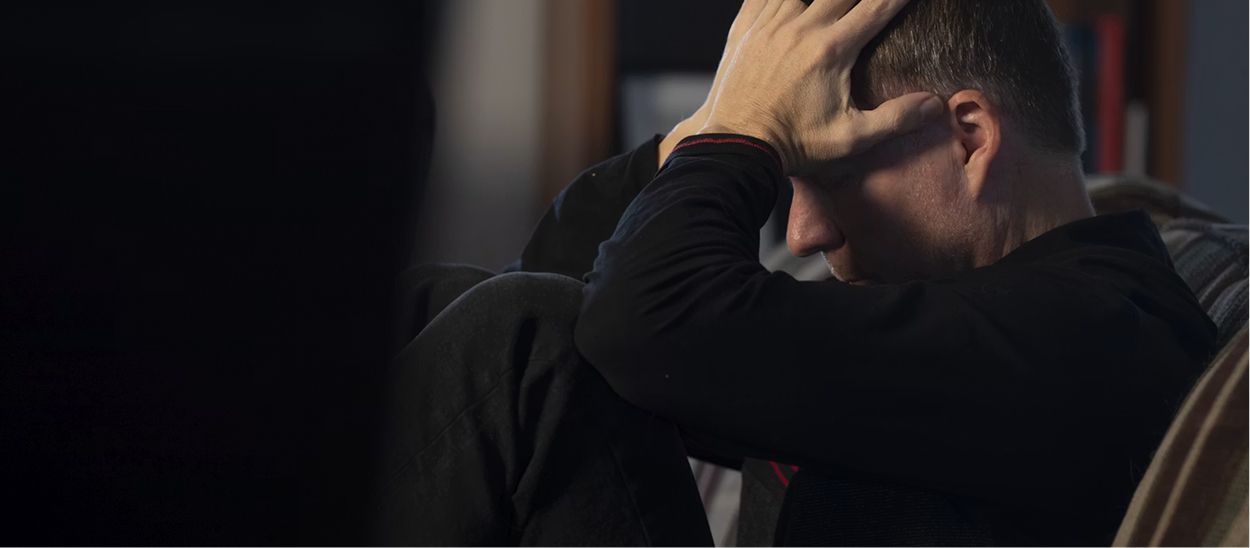 Personne fatiguée avec la main sur le front, montrant la confusion et le brouillard mental causés par le décalage horaire et les symptômes du jet lag après un long voyage