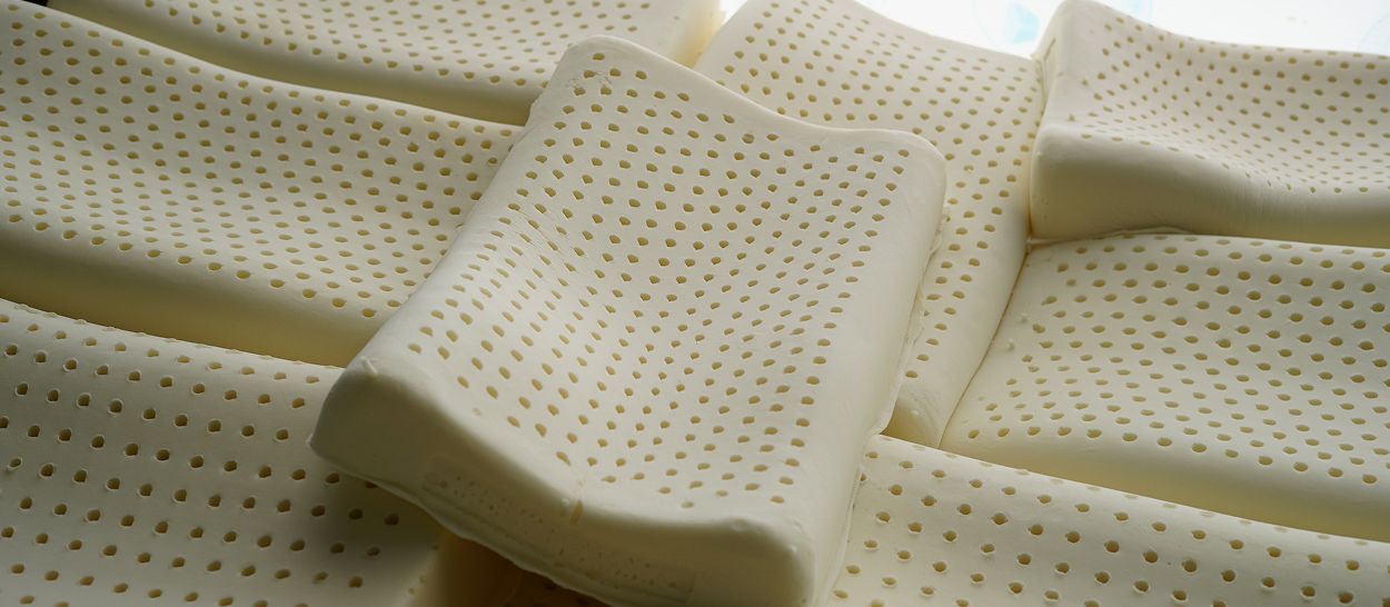 Gros plan sur des blocs de latex naturel percés de milliers d'alvéoles, illustrant la structure alvéolaire ouverte qui assure le soutien, la respirabilité et les propriétés anti-acariens du matelas en latex naturel