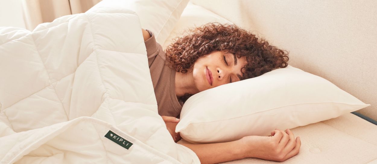 Femme endormie paisiblement sous une couette Kipli au garnissage Tencel, illustrant le confort respirant et thermorégulant de la couette