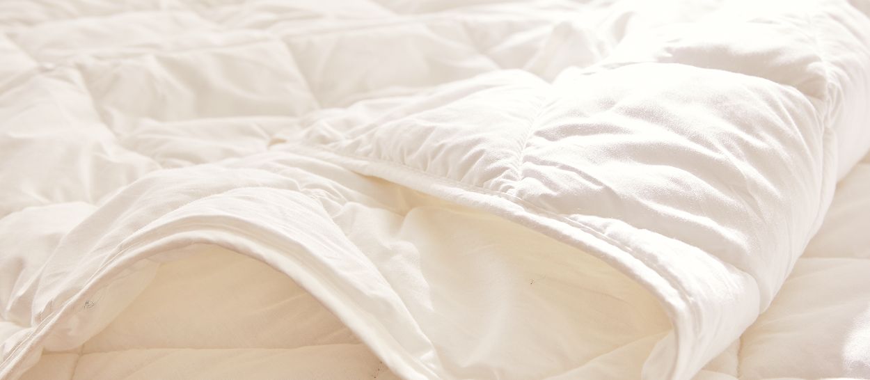 Gros plan sur une couette Kipli au garnissage Tencel, laissant voir son toucher soyeux et sa matière naturelle, facile à entretenir