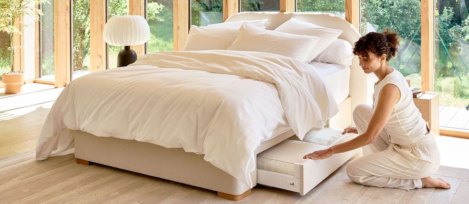 Femme ouvrant le tiroir de rangement d'un sommier tapissier en bois massif