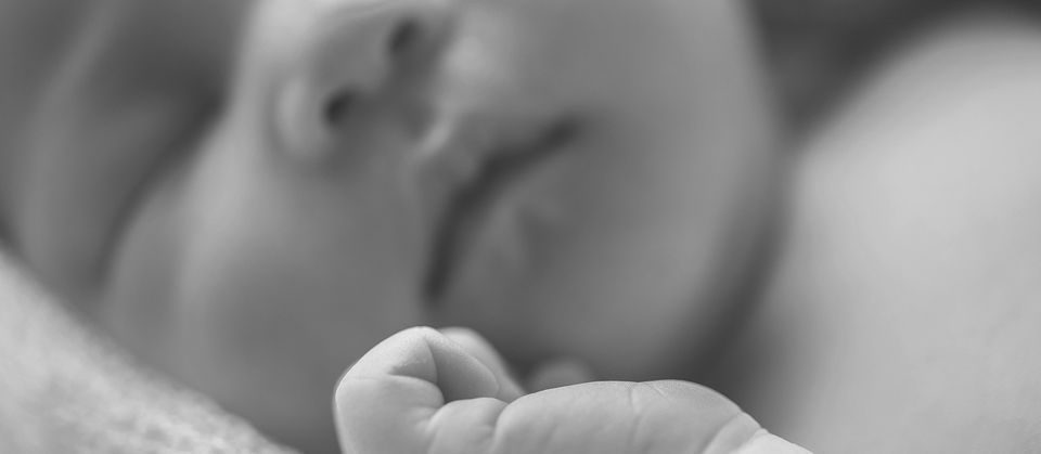 Nourrisson endormi, poing fermé au repos, peau nue sur la collection Kipli bébé