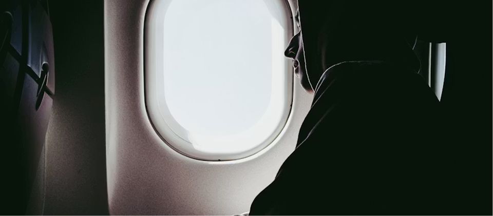 Vue d'une fenêtre d'avion avec hublot illustrant un vol long-courrier et le décalage horaire lors des voyages internationaux